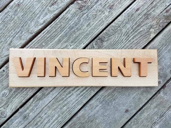 A handcrafted wooden name puzzle where each letter is its own shaped piece — an heirloom-quality toy that doubles as nursery decor.