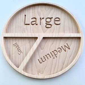 Op de afbeelding: Een houten dienblad met drie secties met de labels "Groot", "Medium" en "Klein".