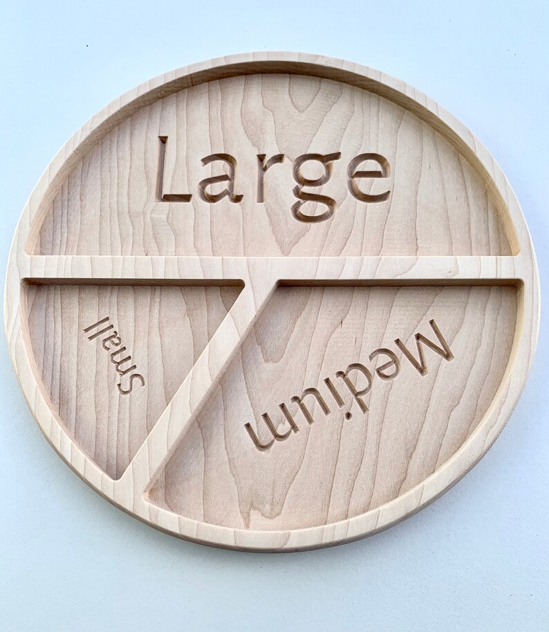 Op de afbeelding: Een houten dienblad met drie secties met de labels "Groot", "Medium" en "Klein".