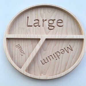 Op de afbeelding: Een houten serveerschaal met drie secties met de labels "Large", "Medium" en "Small".