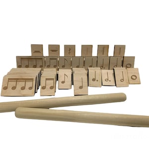 May include: A set of wooden rhythm sticks and a collection of wooden tiles with musical note symbols, including quarter notes, eighth notes, rests, and other musical notation.