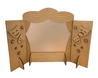 May include: A wooden puppet theater with a light brown finish. The theater has a curved top with a curtain design and two side panels. Each side panel features a star design and a pair of theatrical masks, one smiling and one frowning.