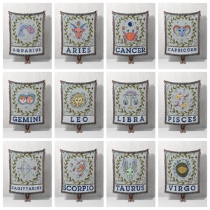 May include: Twelve woven tapestry throw blankets featuring the astrological signs of the zodiac. Each blanket is a light blue color with a green border and a white background. The signs are illustrated in a cartoon style with a variety of colors. The signs are: Aquarius, Aries, Cancer, Capricorn, Gemini, Leo, Libra, Pisces, Sagittarius, Scorpio, Taurus, and Virgo.