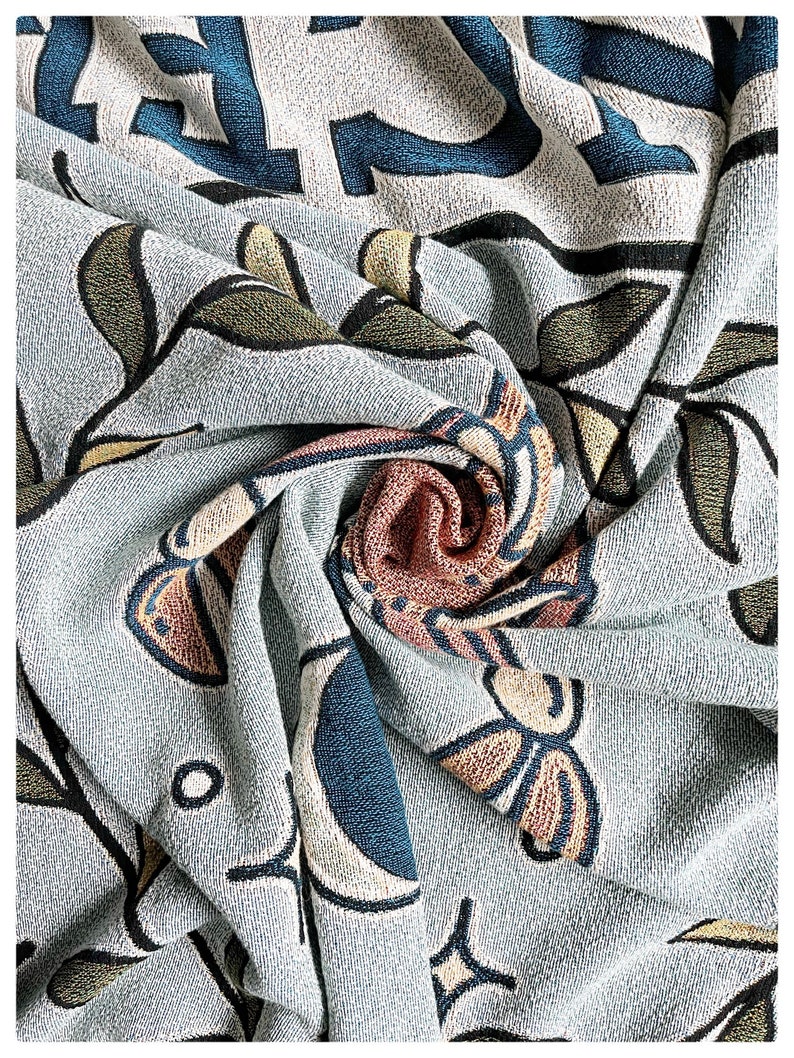 May include: A blue and white patterned throw blanket with a floral design. The blanket is made of a soft, textured fabric and has a subtle sheen.