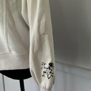 Widespread Panic Cream Colored Sweatshirt with an Embroidered Note Eater on the Sleeve
