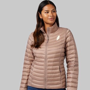 May include: A mauve quilted down jacket with a zipper closure and a white lightning bolt logo on the chest.
