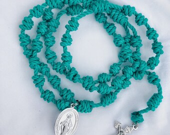 May include: Teal knotted rosary with a silver pendant featuring the Virgin Mary and a silver crucifix.