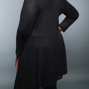 Op de afbeelding: Zwarte lange cardigan met een geribbelde textuur en een high-low zoom. De cardigan is gemaakt van een lichtgewicht, ademende stof.