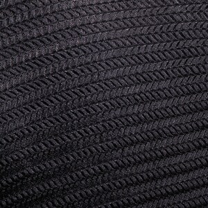 Op de afbeelding: Zwarte stof met een textuur, geweven patroon. De stof heeft een herringbone-ontwerp.