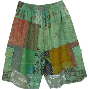 Könnte beinhalten: Grüne Patchwork-Shorts mit Kordelzugbund und mehreren Taschen. Die Shorts bestehen aus verschiedenen Stoffen mit verschiedenen Mustern, darunter Paisley- und Blumenmuster.