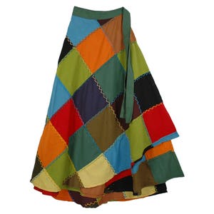 May include: A vibrant patchwork wrap skirt. It's made up of square patches in red, orange, green, blue, and brown. The edges are stitched with contrasting thread, and a green tie fastens the wrap. The skirt is a colourful, bohemian style.