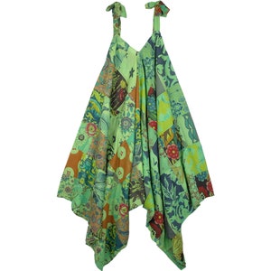 Op de afbeelding: Een groene, blauwe en oranje patchwork jurk met een V-hals en dunne bandjes. De jurk heeft een losse, vloeiende pasvorm en een unieke asymmetrische zoom.
