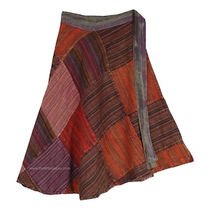 Puede incluir: Una falda de envoltura de retazos con un esquema de color marrón, rojo y morado. La falda está hecha de una tela suave y tejida y tiene una silueta larga y fluida.