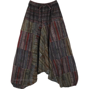 Puede incluir: Un pantalón de estilo patchwork con cintura de cordón. El pantalón está hecho de una variedad de telas en tonos de marrón, gris, rojo y verde. La tela es a rayas y estampada.