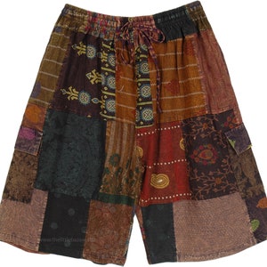May include: Patchwork shorts with a drawstring waist and side pockets. The shorts are made of a variety of fabrics in shades of brown, red, green, and blue. The fabric has a paisley and floral pattern.