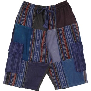 Puede incluir: Pantalones cortos patchwork en tonos azules, grises y burdeos. Los pantalones cortos tienen una cintura con cordón y múltiples paneles de tela con estampados de rayas y geométricos. Dos bolsillos de carga son visibles en la parte delantera.