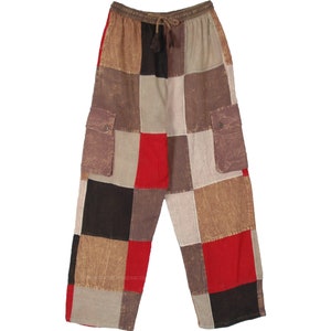 May include: Patchwork pants in a variety of earth tones, including brown, tan, and black, with red accents. The pants have two cargo pockets and a drawstring waist. The fabric appears to be a lightweight material.