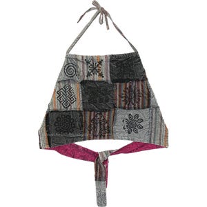 May include: A patchwork halter top with a gray, black, and brown color scheme. The top features various geometric and floral patterns. The interior lining is a vibrant pink, and the top ties at the neck and waist.