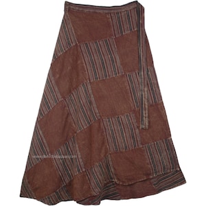 May include: A brown wrap skirt with a patchwork design featuring stripes and solid fabric. The skirt has a long tie that can be wrapped around the waist.