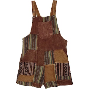 May include: Brown patchwork overall shorts with adjustable straps and a front pocket. The shorts feature a variety of patterned fabric patches in shades of brown, tan, and olive green. The overall shorts are made of a soft, corduroy-like material.