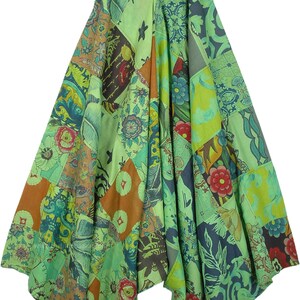 Op de afbeelding: Een groene patchwork jurk met een V-hals en verstelbare bandjes. De jurk is gemaakt van verschillende stoffen met bloemen- en geometrische patronen.