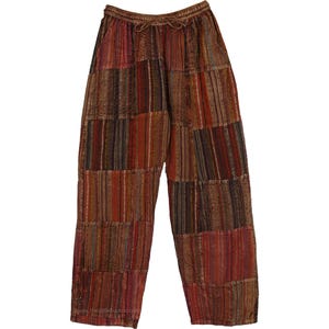 以下が含まれることがあります： 茶色、赤、オレンジの色合いのパッチワークパンツ。パンツは、ドローストリングウエストとゆったりとしたフィット感があります。生地は、縦と横のストライプ模様のミックスです。