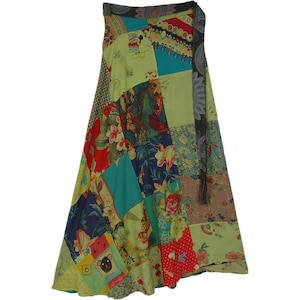 May include: A long, flowing wrap skirt made of patchwork fabric. The skirt is a mix of green, blue, red, and yellow fabrics with floral and geometric patterns. The skirt has a tie closure at the waist.