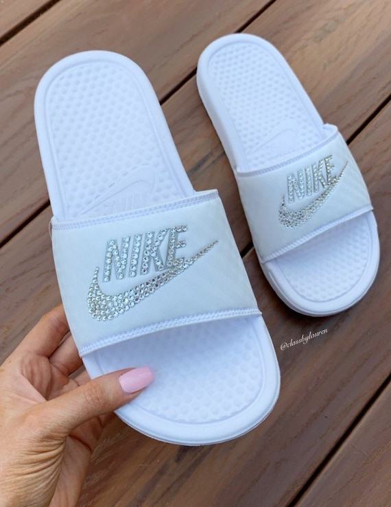 white and silver nike slides