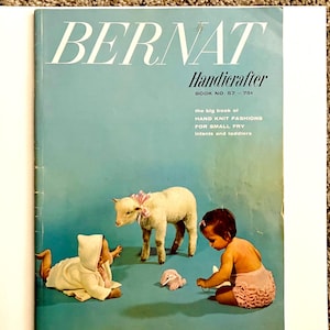 May include: A vintage Bernat Handicrafter book cover with a light blue backdrop. The cover displays the text "BERNAT Handicrafter" and "the big book of HAND KNIT FASHIONS FOR SMALL FRY Infants and toddlers." The image also shows a lamb and two babies.
