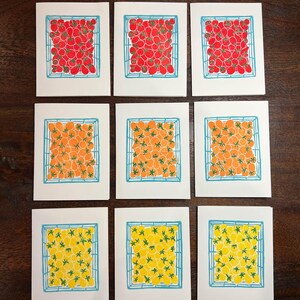 Puede incluir: Nueve tarjetas con ilustraciones de tomates en varios colores. Los tomates est&aacute;n dispuestos en una cuadr&iacute;cula dentro de una cuadr&iacute;cula azul. Las tarjetas son blancas con un borde azul.