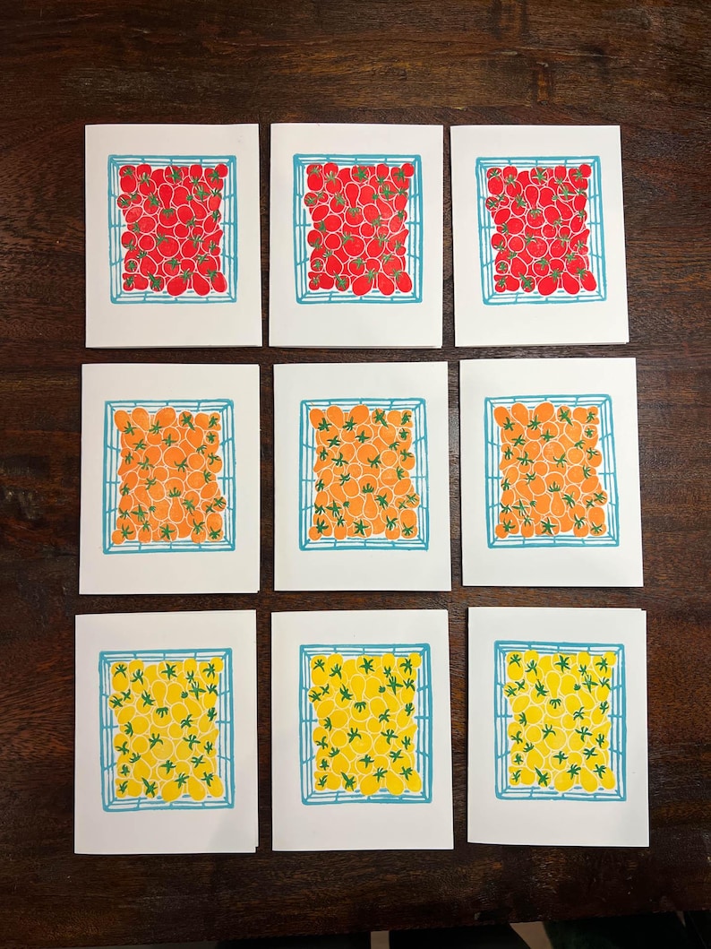 Puede incluir: Nueve tarjetas con ilustraciones de tomates en varios colores. Los tomates est&aacute;n dispuestos en una cuadr&iacute;cula dentro de una cuadr&iacute;cula azul. Las tarjetas son blancas con un borde azul.