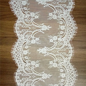 Puede incluir: Borde de encaje blanco con borde festoneado y patrón floral.