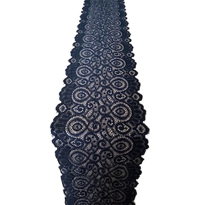 May include: Black lace trim with a delicate floral pattern. The lace is about 1 inch wide and has a scalloped edge.