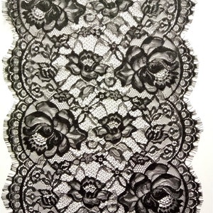 Puede incluir: Borde de encaje negro con un patrón floral. El encaje tiene un borde festoneado.