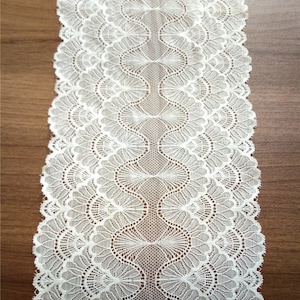 May include: White lace trim with a delicate scalloped edge and a repeating pattern of fan-shaped designs.