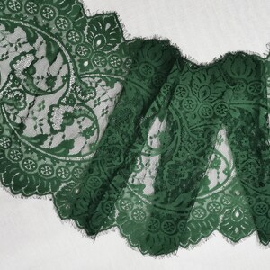 May include: Green lace trim with a scalloped edge and a floral pattern.