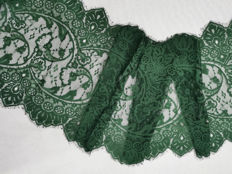 May include: Green lace trim with a scalloped edge and a floral pattern.