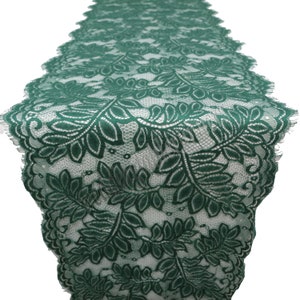 May include: Green lace trim with a leafy pattern. The lace is delicate and has a scalloped edge.