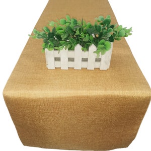 Può includere: Un runner da tavolo dorato con un leggero luccichio. Il runner è realizzato in tessuto strutturato ed è perfetto per aggiungere un tocco di eleganza a qualsiasi mise en place.