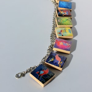 Pulsera con dije de ficha de Scrabble inspirada en el pato Darkwing