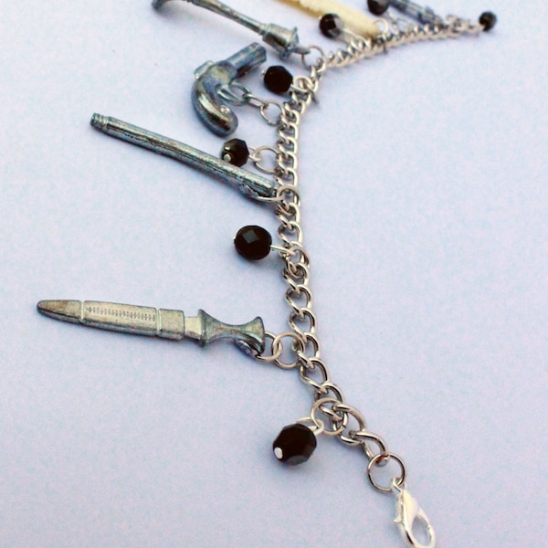 Pulsera con dijes de Clue Token y cuentas negras