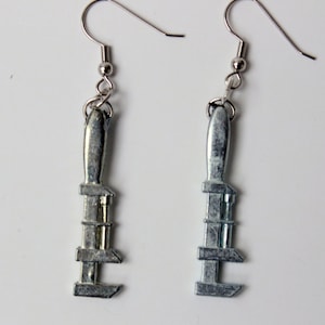 May include: A pair of silver adjustable wrench earrings. The earrings are made of metal and have a silver finish. The wrenches are about 2 inches long.