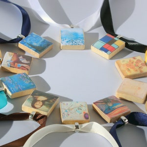 May include: A set of 12 wooden pendants with different famous paintings printed on them. Each pendant is attached to a ribbon of a different color, including white, black, yellow, brown, blue, and turquoise.
