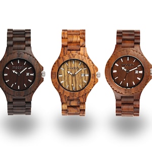 May include: Three wooden wristwatches with brown, light brown, and dark brown wood bands. The watch faces are all different, with one having a dark brown face, one having a light brown face, and one having a wood grain face. All watches have the word "modply" printed on the face.