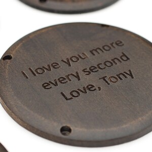 以下が含まれることがあります： 「I love you more every second Love, Tony」という文字が刻まれた、濃い茶色の木製の円形です。