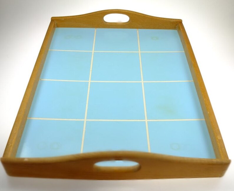Puede incluir: Una bandeja de servir de madera con una superficie de azulejos de color azul claro. La bandeja tiene dos asas a los lados y una en la parte delantera.