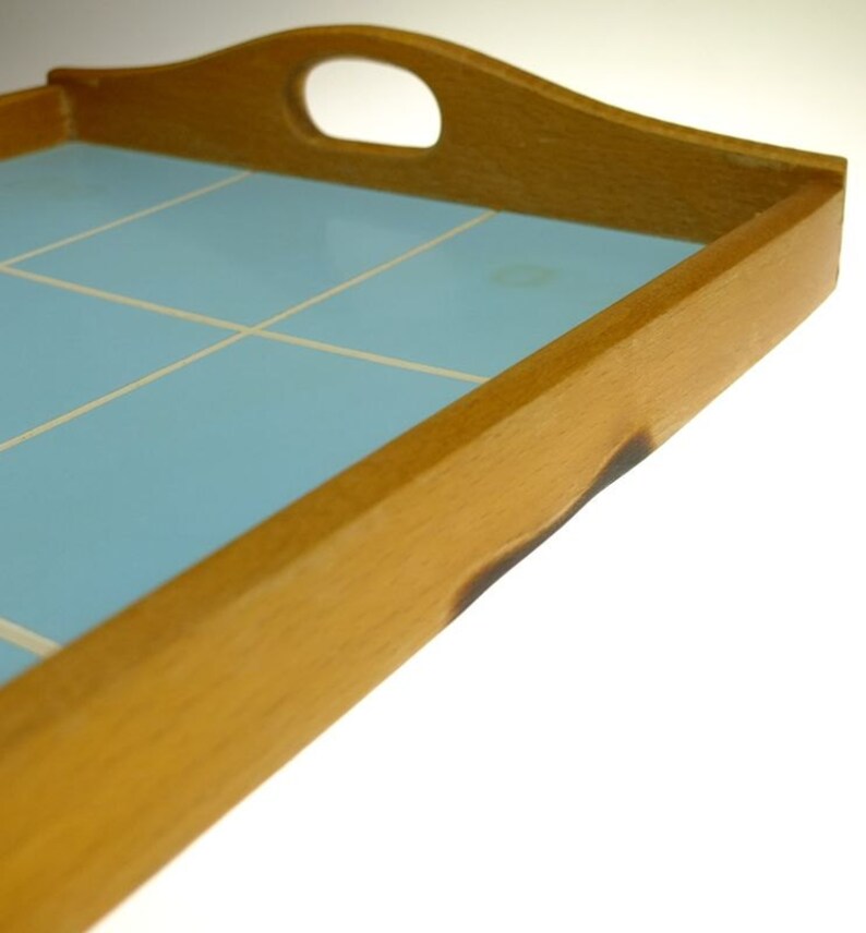 Puede incluir: Una bandeja de servir de madera con una superficie de azulejos de color azul claro. La bandeja tiene un asa en la parte superior y est&aacute; hecha de madera natural.