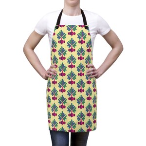 May include: A yellow kitchen apron with a repeating pattern of stylized beets in shades of green, purple, and red.