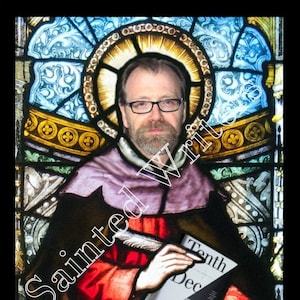May include: A stained-glass depiction of Saint George, holding a book titled "Tenth December." The image features a man with glasses and a beard, dressed in a red and black robe, set against a colorful stained-glass background. A gold sign at the bottom reads "SAINT GEORGE."