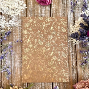 Pu&ograve; includere: Carta da regalo marrone con un motivo floreale in foglia d'oro. Il motivo presenta foglie e fiori delicati.